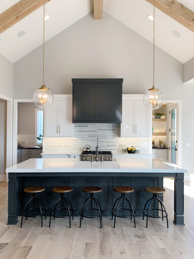 Black and white modern farmhouse kitchen Modern Farmhouse kitchen features bright cabinets and countertops with accents of Sherwin Williams SW 7069 Iron Ore on the island and hood Black and white modern farmhouse kitchen #Blackandwhitekitchen #modernfarmhousekitchen #ModernFarmhouse #kitchen #cabinets #countertops #SherwinWilliamsSW7069IronOre #island #hood