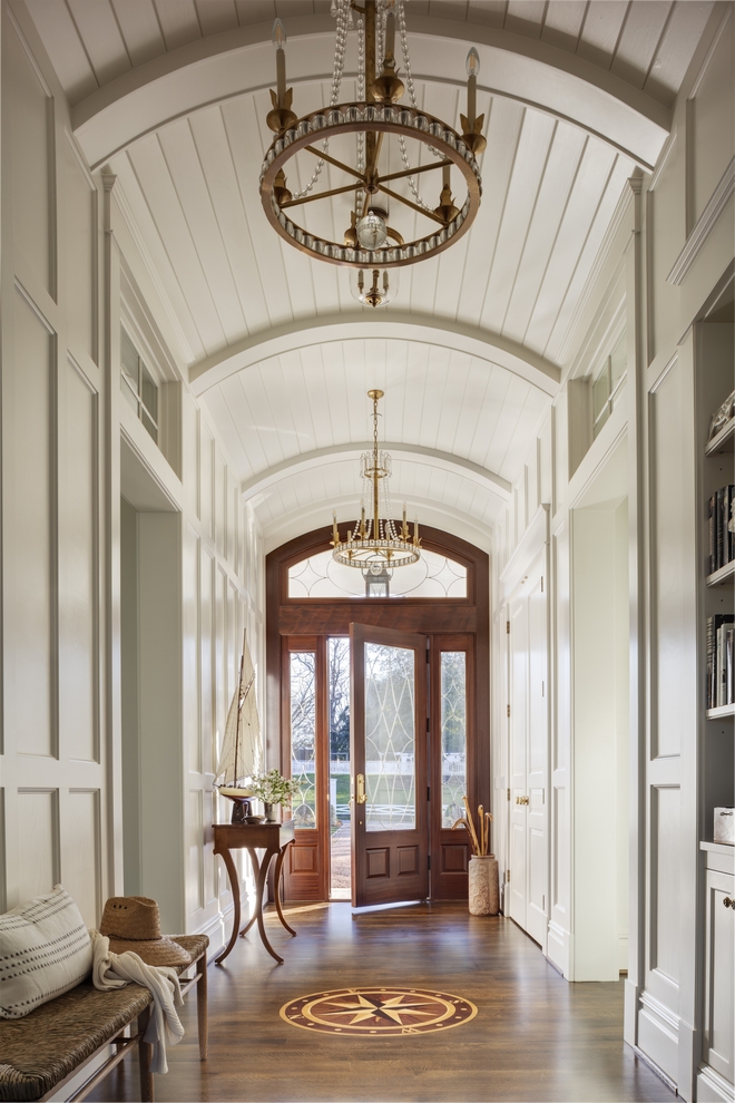 Classic Foyer Coastal Home Upon entry guests are met with a handcrafted compass inlay indicating true north while the extensive millwork curved beadboard ceilings and built-in cabinetry and bookcases evoke the character of shipbuilding Classic Foyer Barrel Ceiling Coastal Home Classic Foyer Coastal Home Classic Foyer Coastal Home #ClassicCoastalhome #Foyer #CoastalHome #handcraftedcompassinlay #compass #millwork #curvedceiling #barrelceiling #beadboardceilings #builtincabinetry #bookcases