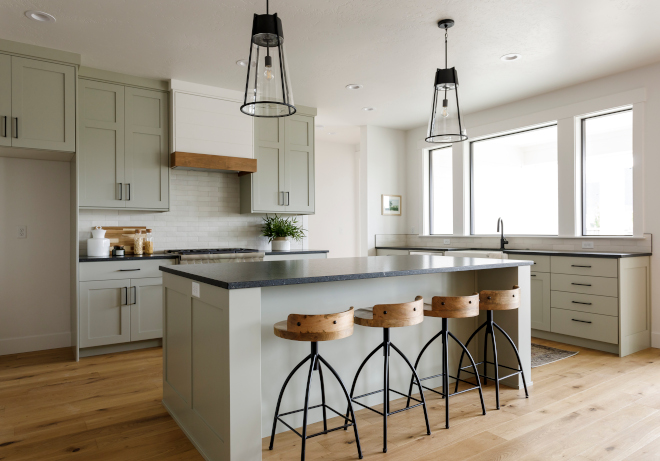  This warm kitchen wows with relaxing symmetry and calming gray hues Shaker kitchen cabinet doors create interest and pair well with the leathered countertops on both kitchen islands and the perimeter In this kitchen gray cabinets are outfitted with black hardware #warmkitchen #kitchensymmetry #graykitchen #Shakerkitchencabinet #cabinetdoor #leatheredcountertop #kitchenislands #perimeter #graycabinets #blackhardware