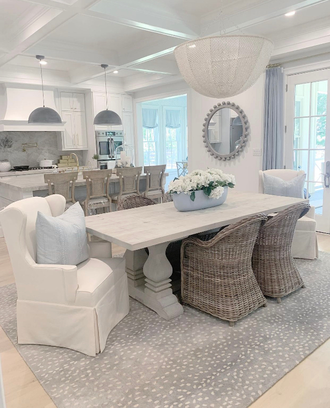 White French Country Kitchen Dining Room with grey dining table wicker dining chairs slipcovered host dining chairs beaded mirror coastal beaded chandelier light fixture and antelope rug #WhiteFrenchCountryKitchen #DiningRoom #greydiningtable #diningtable #wickerdiningchair #slipcovereddiningchair #beadedmirror #coastalbeadedchandelier #beadedchandelier #lightfixture #anteloperug