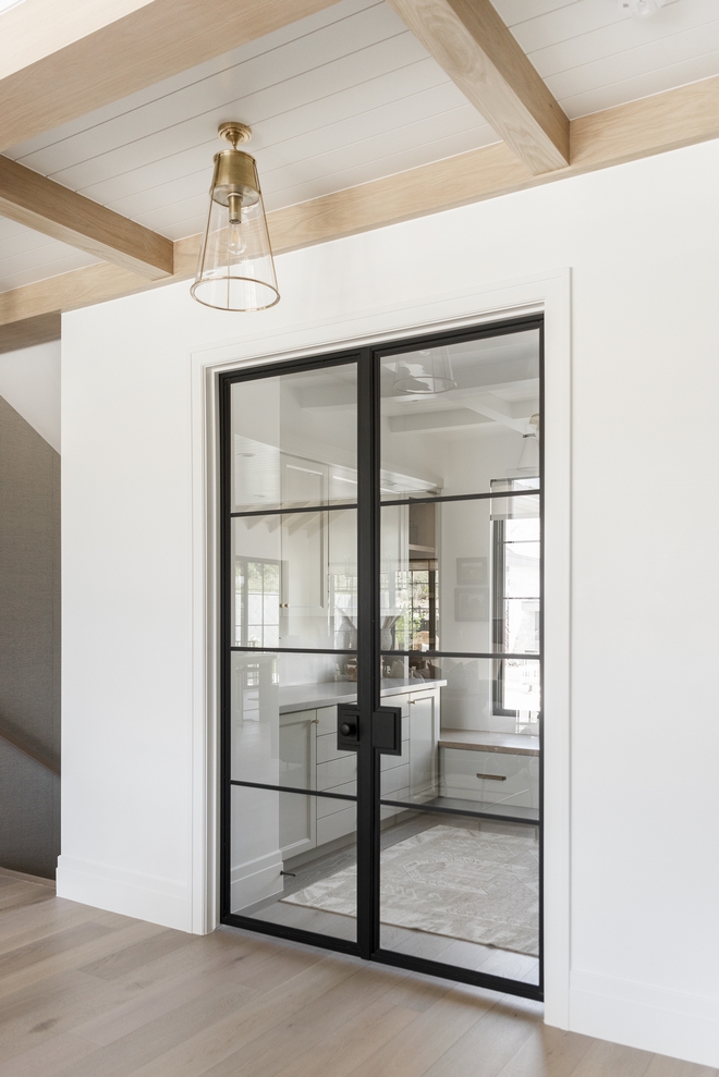 The main home office is concealed by custom black metal and glass doors and it features plenty of built-ins #homeoffice #customdoor #metaldoor #glassandmetaldoor