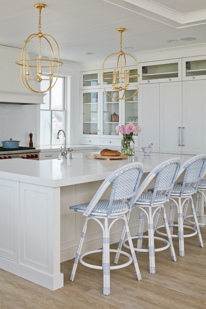 White Kitchen with White Quartz Countertop Crisp white quartz countertops glass cabinets and gold pendants add a touch of coastal elegance to this white kitchen White Kitchen with White Quartz Countertop Crisp white quartz countertops glass cabinets and gold pendants add a touch of coastal elegance to this white kitchen #WhiteKitchen #WhiteQuartz #whiteCountertop #Crispwhite #quartzcountertops #glasscabinets #goldpendants #coastalkitchen #kitchen