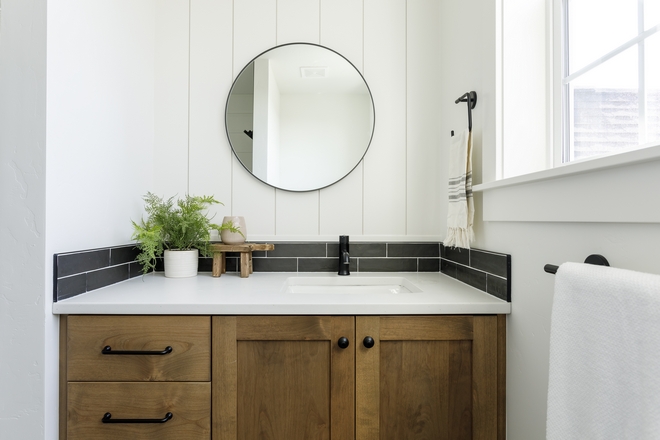 Right beside the custom shelves you will find a custom Oak vanity with vertical shiplap backsplash