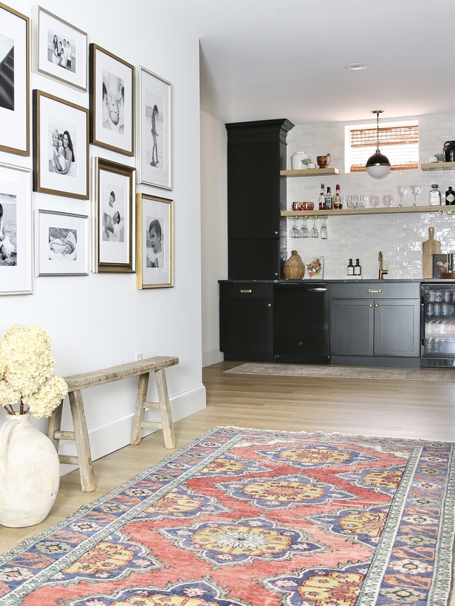 Vintage Rug Vintage bench in a hallway with black bar cabinets in Sherwin Williams Black Magic