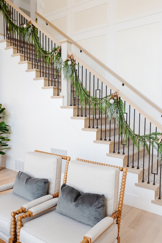 Cedar garlands and Christmas ornaments dress the long staircase railing.