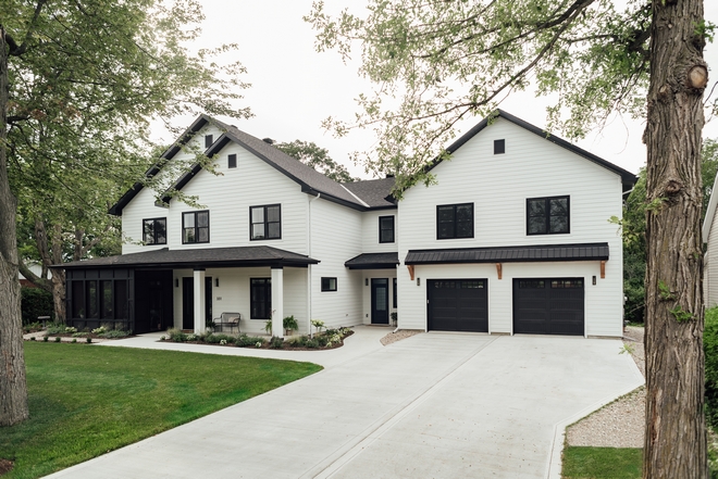 James Hardie exterior cladding in their classic Arctic White lapped horizontal siding paired with contrasting black windows and warm wood tones give the exterior a classic yet contemporary feel