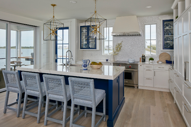 The stunning kitchen features extra thick porcelain countertops blue island with matching blue front glass cabinets and gorgeous glass mosaic backsplash that glistens in the sunlight that glistens in the sunlight #kitchen #extrathickcountertop #porcelaincountertop #blueisland #frontglasscabinet #glassmosaicbacksplash #mosaicbacksplash #backsplash
