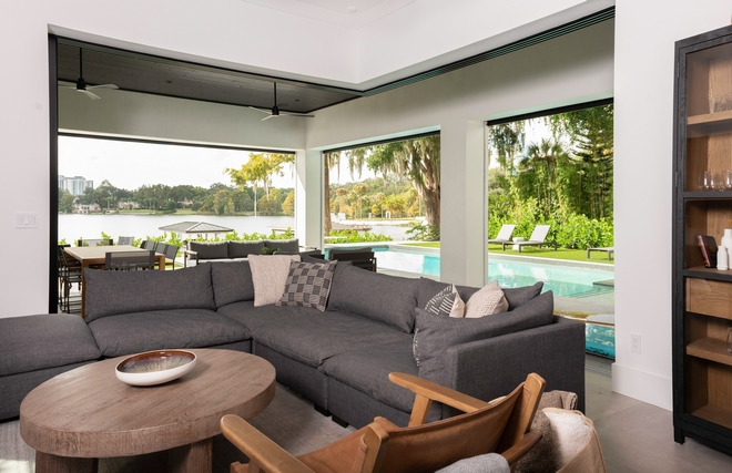 The TV room reflects the home’s indoor/outdoor living design, brought to life with pocket moving glass doors that welcome the outdoors in. The porcelain rectified tile, custom- stained exterior ceiling, and sleek, minimalistic outdoor fans create a cozy modern feel that can withstand daily traffic and use