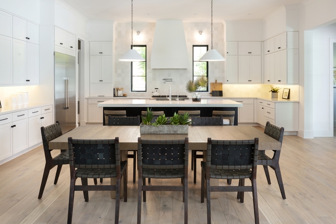 This open concept all-white kitchen and dining space is designed for entertaining with its oversized white quartz island and vast counter space #whitekitchen #openkitchen #openconceptkitchen #kitchendesign #kitchen 