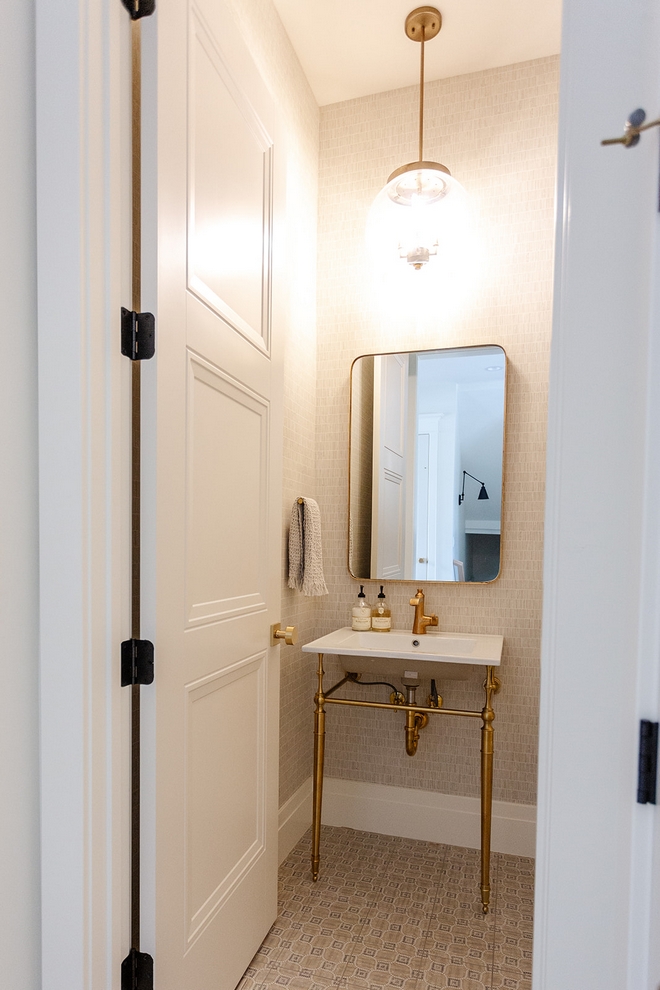Powder Room Touches of brushed brass along with patterned floor tile and neutral wallcovering add a glamorous feel to this Powder Room Powder Room Powder Room #PowderRoom #patternedtile #brushedbrass #wallcovering