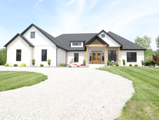 A winding pebble driveway leads you to this beautiful Modern Farmhouse home with front porch #Modernfarmhouse #windingdriveway #pebbledriveway #driveway #frontporch