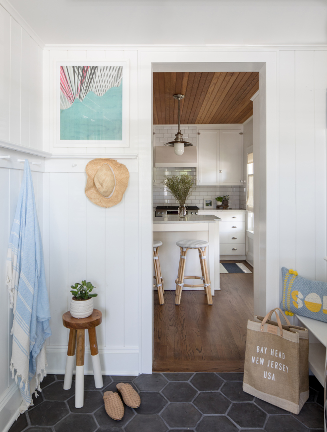 We modernized this multi-functional space laundry and mudroom with vertical paneling and cool and earthy terracotta tile #mudroom #laundryroom