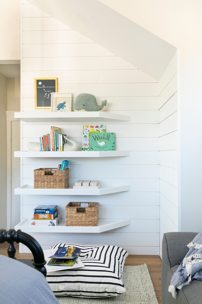 Custom floating shelves along with an oversized floor pillow create a great spot for reading