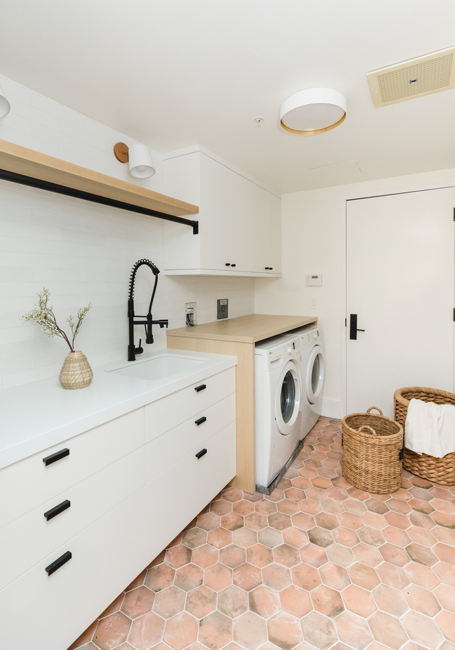 This renovated Laundry Room features hexagon terracotta floor tile and new cabinetry