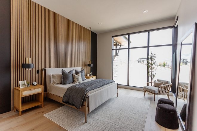 Floor-to-ceiling windows bring in plenty of natural light while a custom slat wood paneling gives warmth and interest to the space Bedroom Design #Bedroom #Bedroomdesign