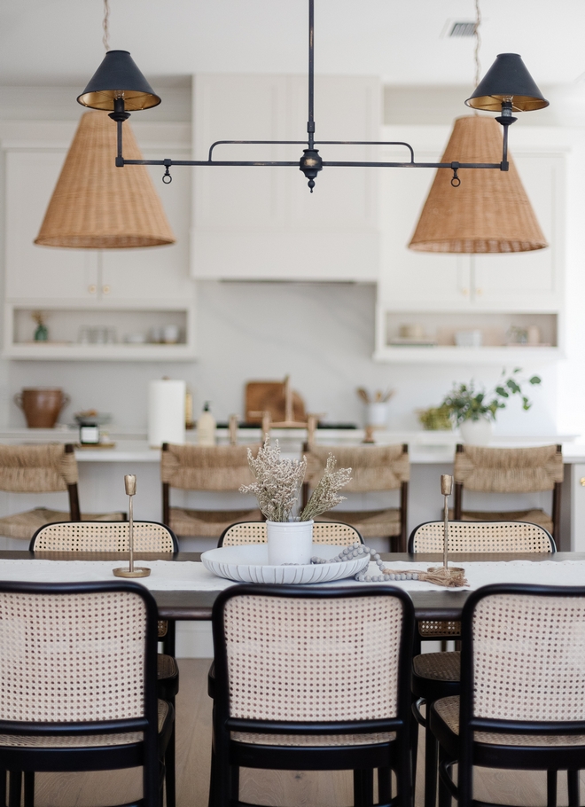 The dining room is a bit more elevated with a French Parisian inspired dining table wood and woven dining chairs and a linear chandelier #diningroom #French #Parisian #Frenchinspired #diningtable #woodandwovendiningchair #canediningchairs #linearchandelier