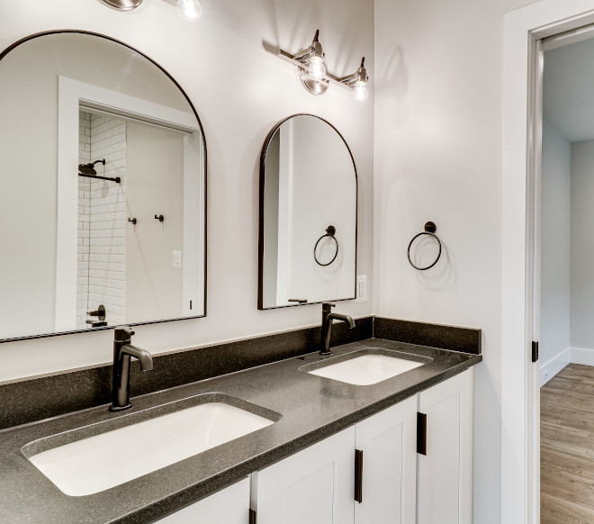 The arched mirrors soften the high contrasting tones and straight lines in this Bathroom #Bathroom