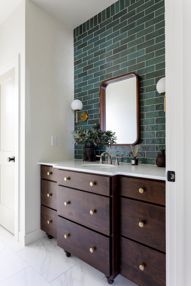 The bathroom has a beautiful green tile that makes the vanity area stand out #bathroom