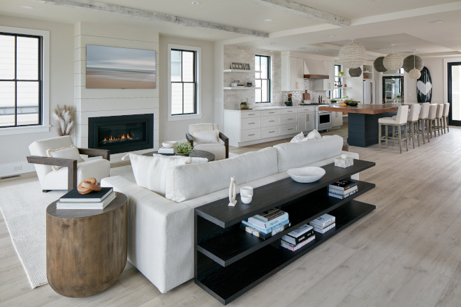 This open-concept living room features whitewashed beams and a fireplace clad in shiplap #livingroom #whitewashed #beams #shiplap