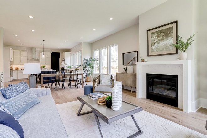 A simple field-built mantle and Cashmere Carrara Quartz fireplace surround tie the joining spaces together creating a peaceful effortless look #fireplace #mantel