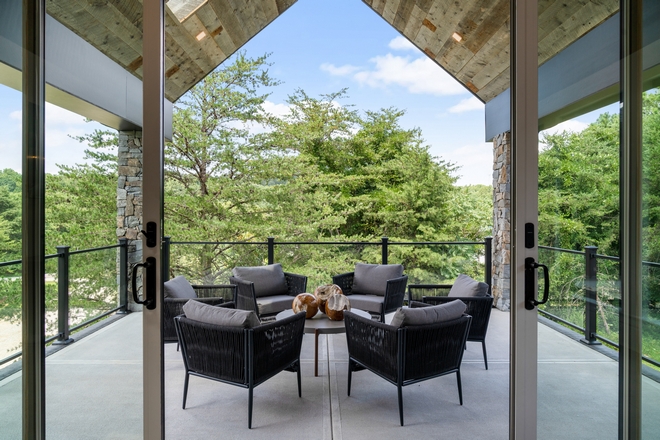 Sliding patio doors open onto a covered deck with a calming view of the treed backyard