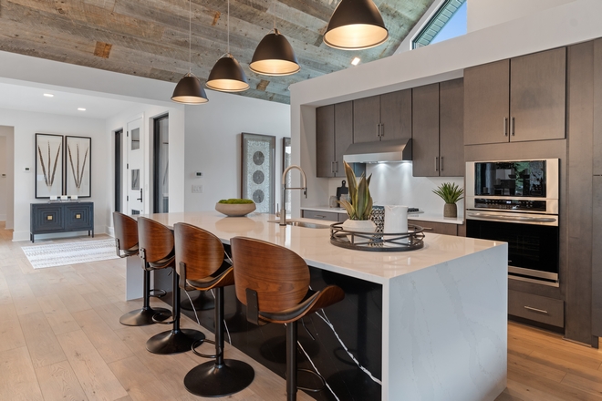 Waterfall Kitchen Island The island is truly luxe with its dramatically veined solid surface facing and waterfall countertop #waterfallisland #kitchenisland
