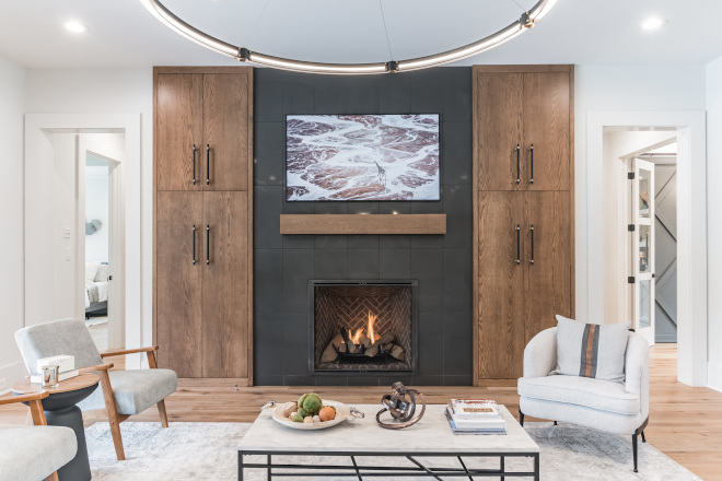 The fireplace is the focal point of this space The dark tile and the warm wood custom built-ins #livingroom #fireplace #fireplacebuiltins #fireplacebuiltinsideas