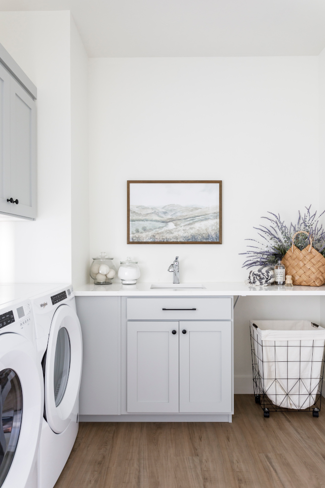 This laundry room keeps it simple and functional with a sink extra counter space room for rolling laundry bins and cabinetry for storage #laundryroom