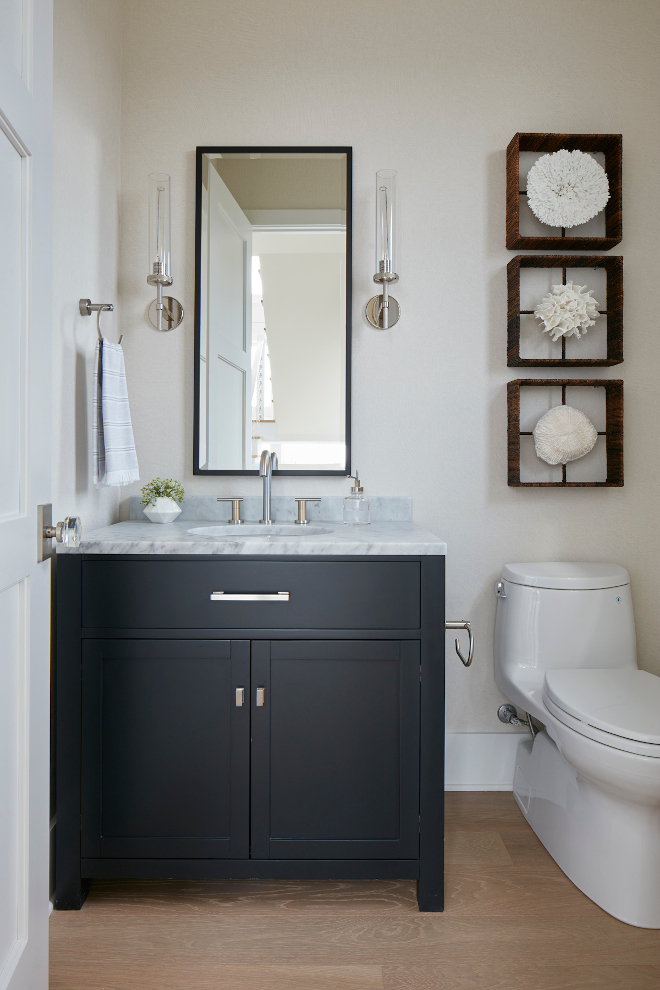 A navy blue vanity adds a classic coastal feel to this Powder Room #powderroom #navyblue