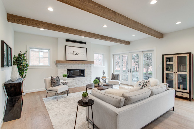 Living Room A stone fireplace with wood mantle to complement the three wood beams created a cozy ambiance despite the rooms large open concept layout Living Room A stone fireplace with wood mantle to complement the three wood beams created a cozy ambiance despite the rooms large open concept layout #greatroom