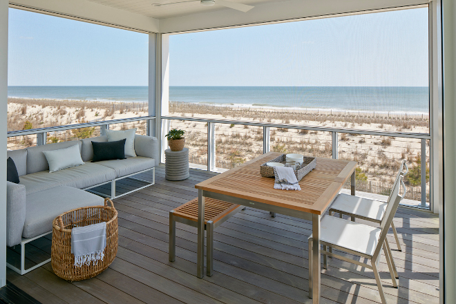 The Great Room opens onto a screened-in porch with modern outdoor furniture and an ample ocean view #screenedinporch #screenedporch