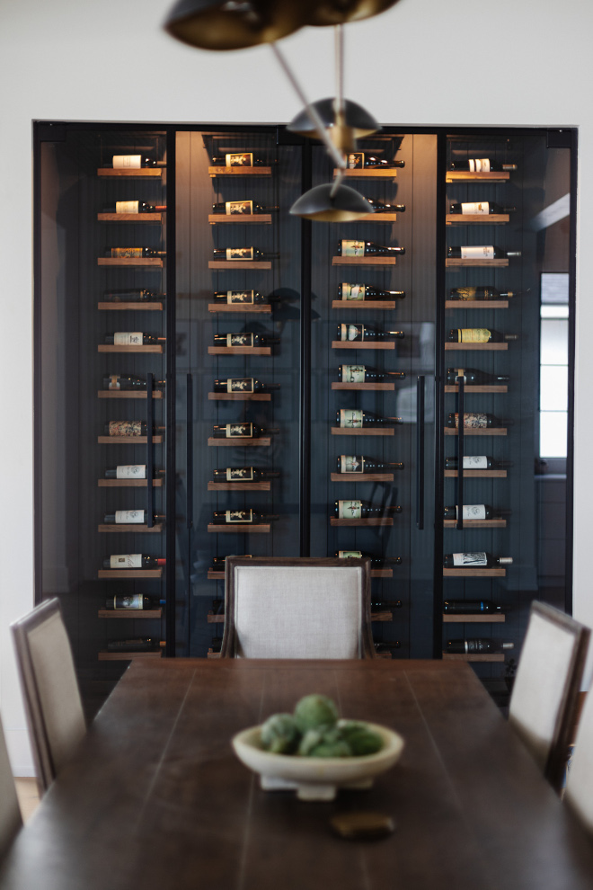 Dining room features a glass enclosed wine storage with floor-to-ceiling floating shelves #diningroom #wineroom