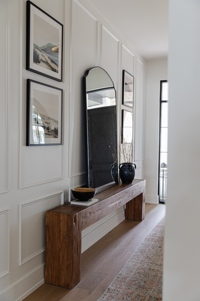 The foyer was layered with picture frame moulding with of course family photos a rustic massive console table #foyer #pictureframemoulding #paneling #consoletable