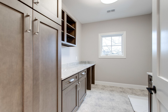 Large laundry room is equipped with plentiful cabinets for storing household essentials