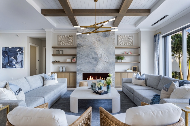 The living room includes a dramatic floor-to-ceiling slab fireplace flanked by custom built-ins #livingroom #floortoceilingfireplace #slabfireplace #custombuiltins