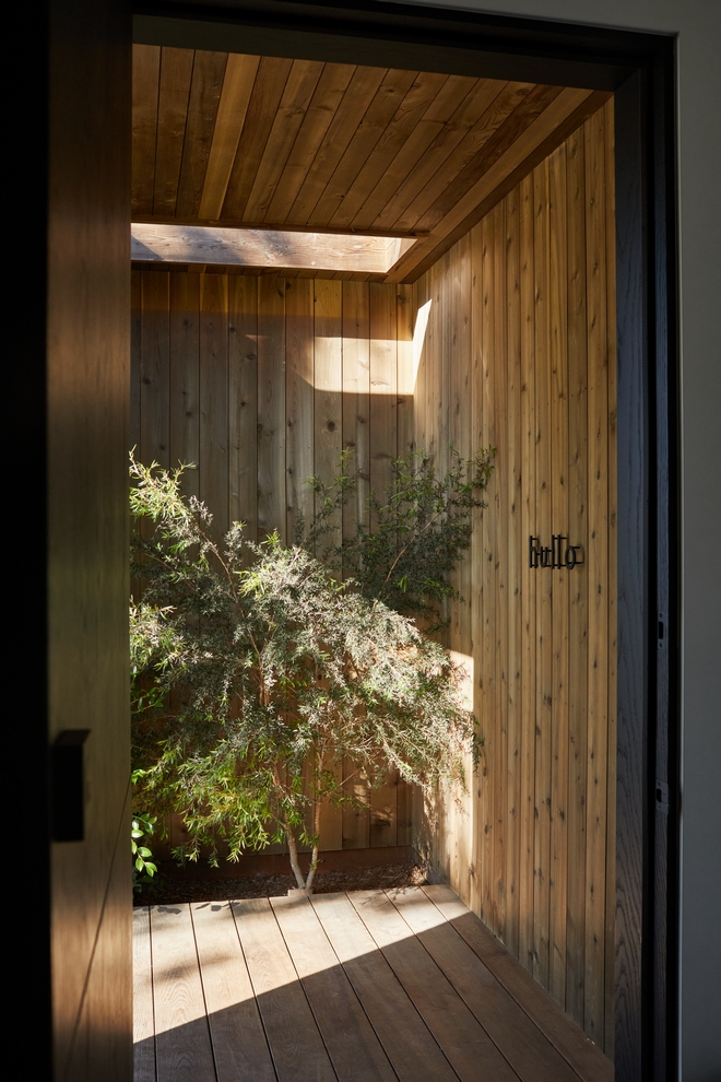 This front entry designed by architect Eric Olsen captures the entire inside referencing a naturally modern aesthetic Cedar mixed with strong board formed concrete is a show-stopper #frontentry #architect #EricOlsen #natural #modern #Cedar #boardformedconcrete