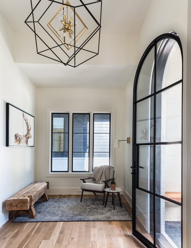 Foyer Design A custom custom iron arched glass door unique decor along with a large geometric chandelier gives an authentic first look at this stunning Charlotte home #FoyerDesign #Foyer #Home #Foyerdesign