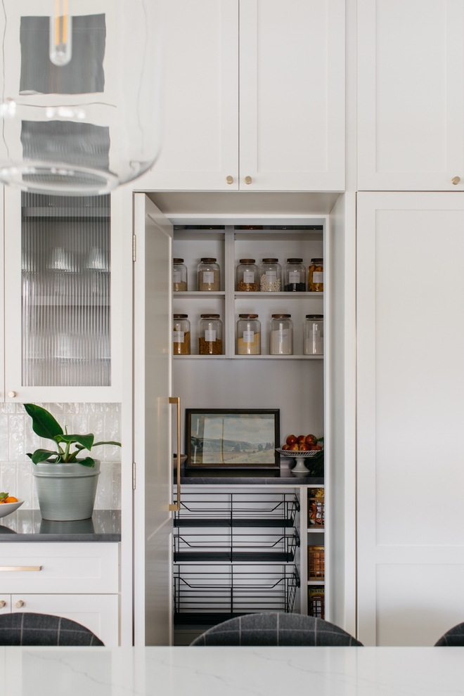 Hidden Pantry A cabinet door mimicking the panel-ready fridge and freezer conceal a walk-in pantry with custom cabinetry #kitchen #HiddenPantry #Pantry #walkinpantry