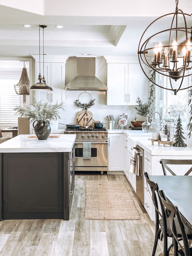 How to decorate a kitchen for Christmas added holiday candles darker wooden serving boards to create a contrast against the white countertops and a dark vase in the center of the island along with some Christmas kitchen towels and a candle #Christmaskitchen