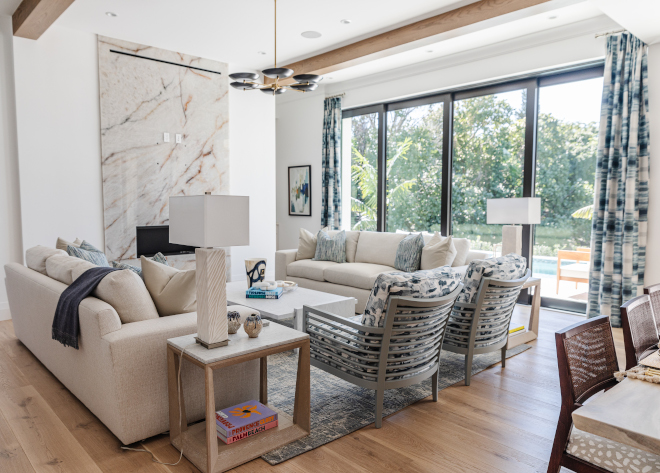 A floor-to-ceiling slab fireplace serves as a stunning focal point in this inviting living area #livingroom #slabfireplace #fireplace