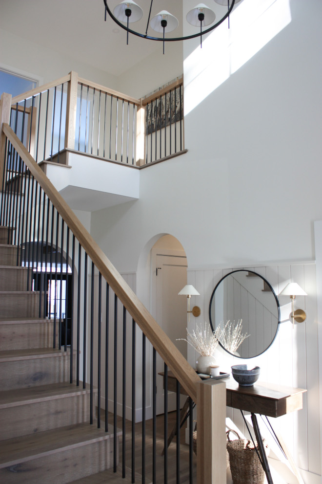Modern white oak staircase Featuring a subtle curve for slight motion a white oak handrail for warmth with masculine matte black spindles #Modernstaircae #whiteoak #staircase #whiteoakstaircase #whiteoakstair #handrail #matteblackspindles