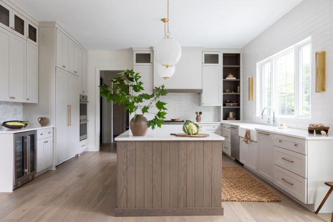 Soft light grey kitchen cabinets are beautifully complemented by a White Oak island featuring shiplap on its ends #lightgreykitchen #cabinet #WhiteOakisland #shiplap