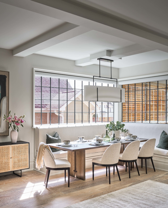 The breakfast nook features a custom banquette nestled in a corner highlighted by windows with black grid patterns The breakfast nook features a custom banquette nestled in a corner highlighted by windows with black grid patterns #breakfastnook #banquette #windows #blackgridwindow