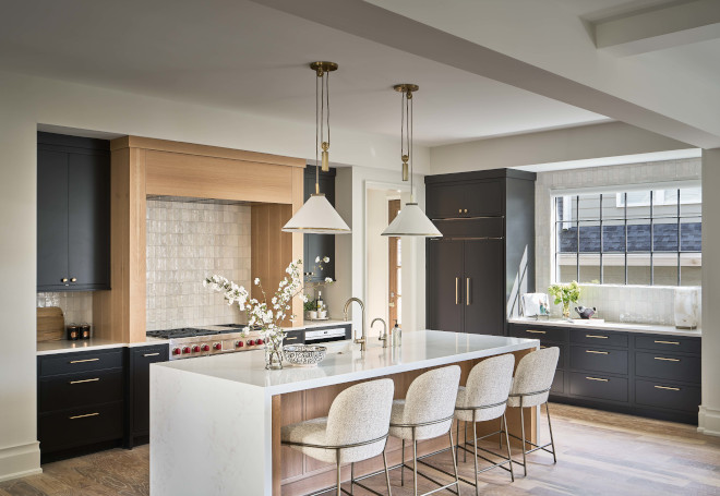 The contrasting colors of the black cabinets and white oak island create a striking visual appeal in this modern kitchen #contrastingcolors #blackcabinet #whiteoak #island #modernkitchen #kitchen