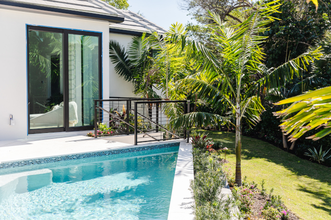 This idyllic Florida home is adorned with lush tropical gardens and features a pool that overlooks the tranquil canal