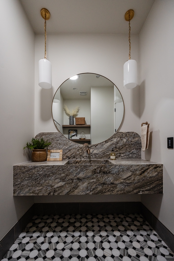 This powder room is captivating and makes you pause to appreciate its beauty I love the mirror integrated seamlessly into the backsplash design Gorgeous