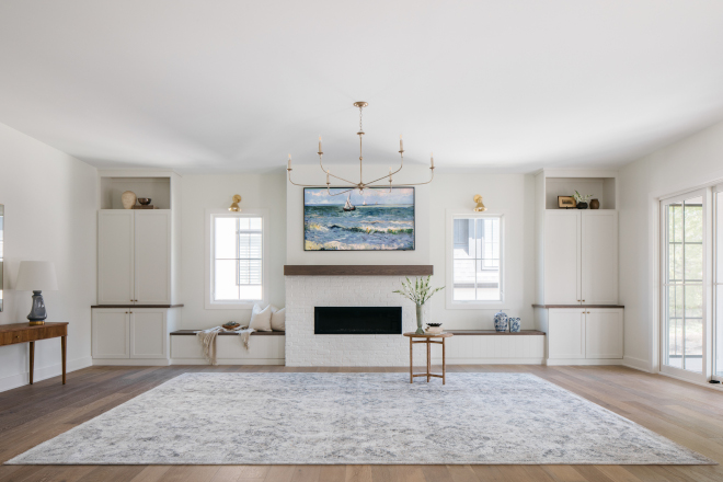 The great room features a painted brick fireplace surrounded window-seats and built-in cabinets #greatroom #paintedbrick #fireplace #windowseat #builtin #cabinets