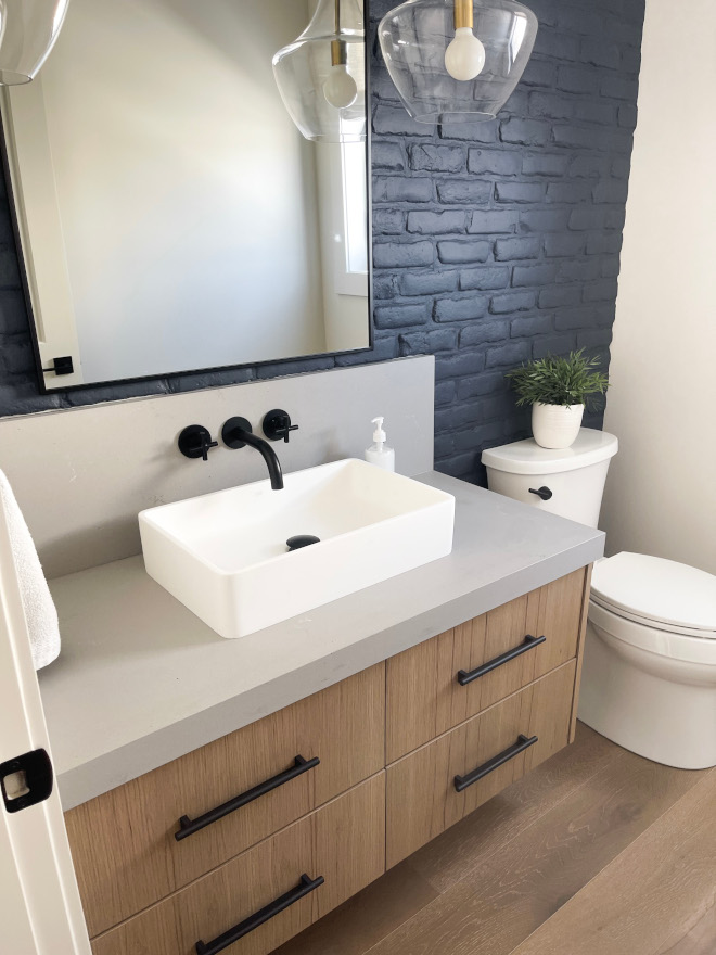 Stepping into the powder room your eyes are immediately drawn to the striking dark brick feature wall in Sherwin Williams Iron Ore #powderroom #darkbrick #SherwinWilliamsIronOre