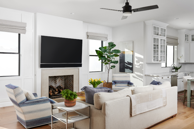 The kitchen opens into a family room with a fireplace and French doors to the backyard #familyroom