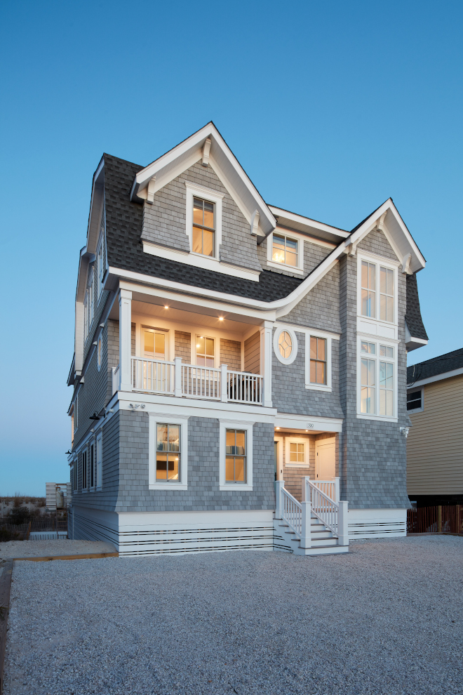 A shingle beach house boasting grey shingles complemented by sharp white trim and accents #shingle #beachhouse #shinglesiding